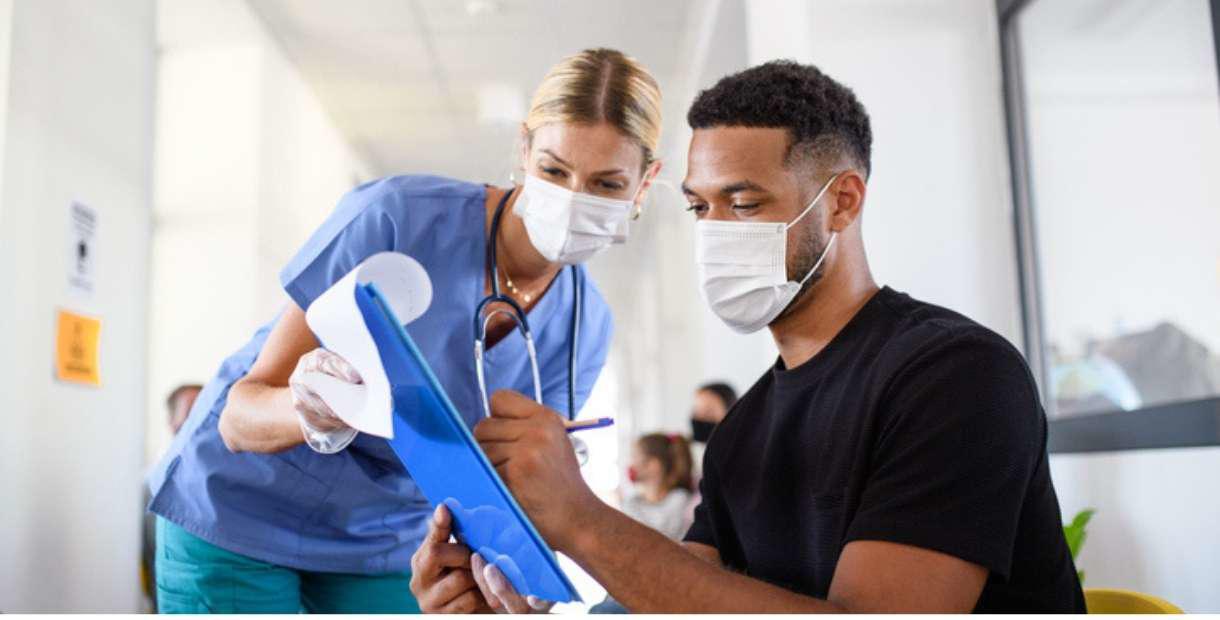 Doctor and Nurse wearing masks working on paperwork.