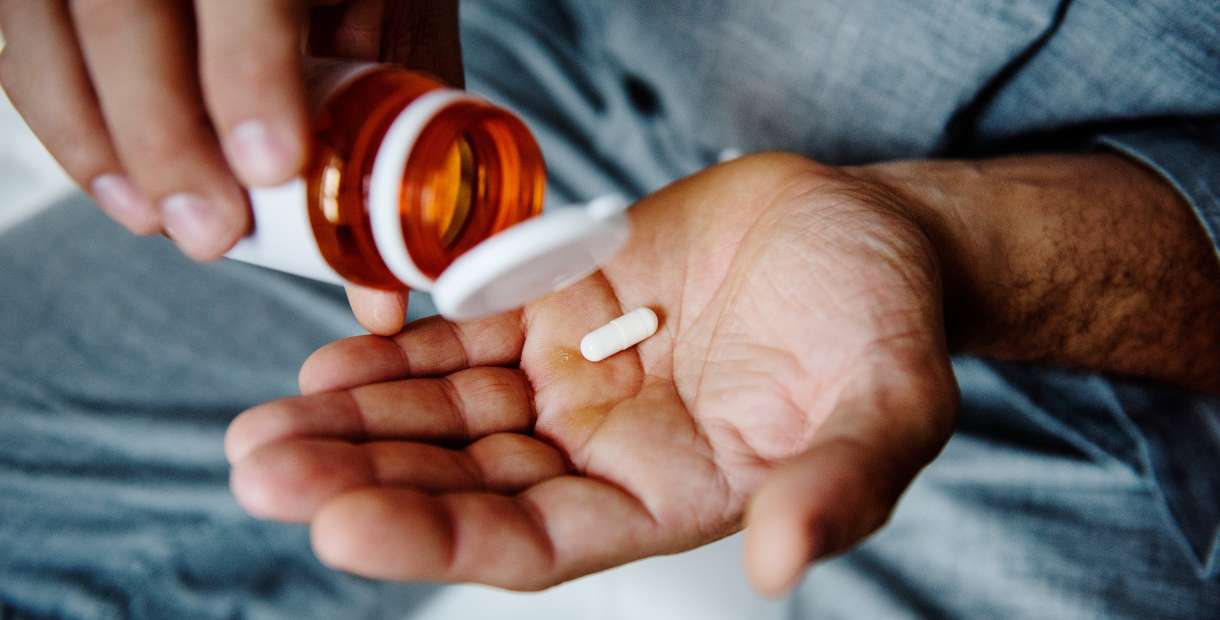 Hands holding a pill.
