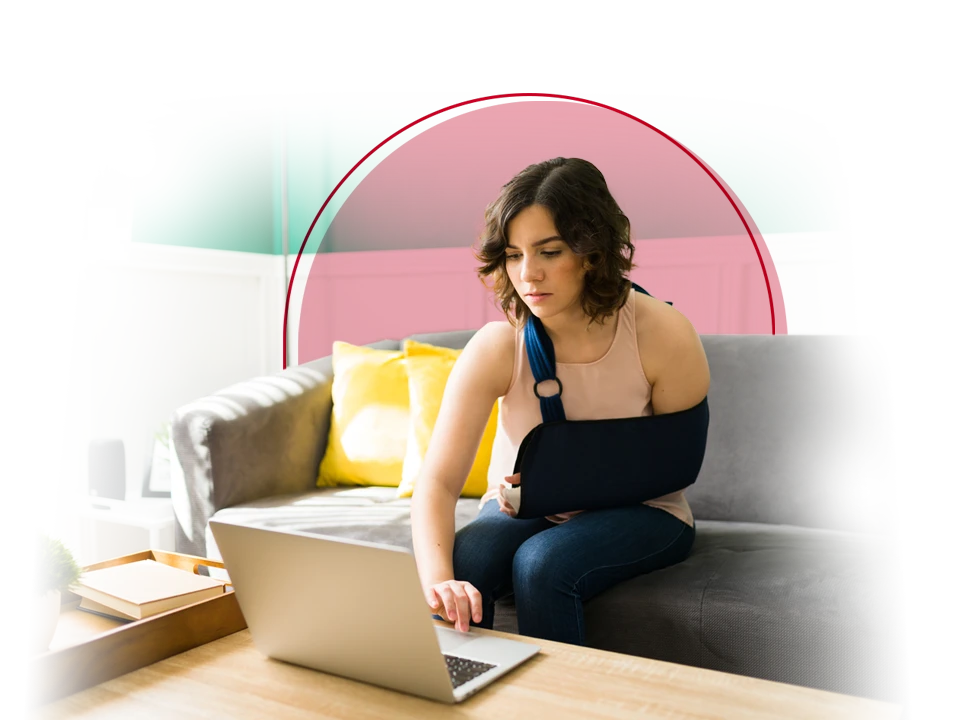 Woman in an arm sling working on her computer.