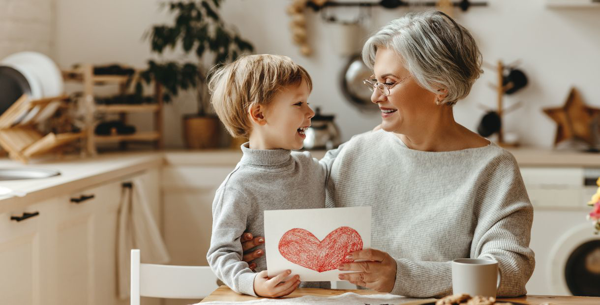 A woman and child holding a drawing together.