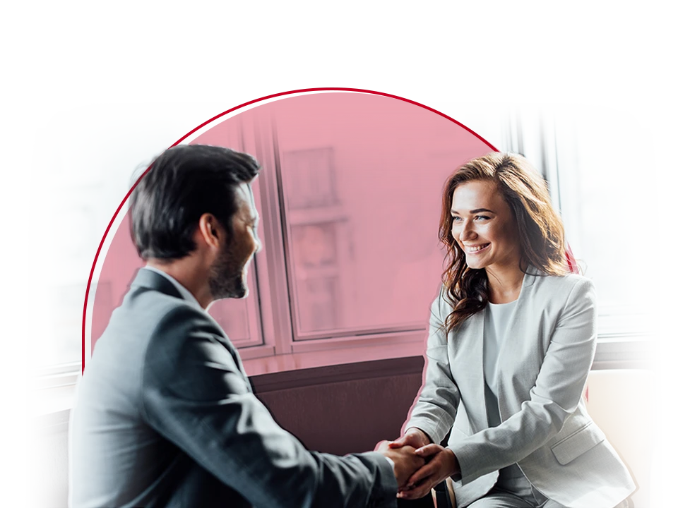 Male and female shake hands during a one-on-one meeting.