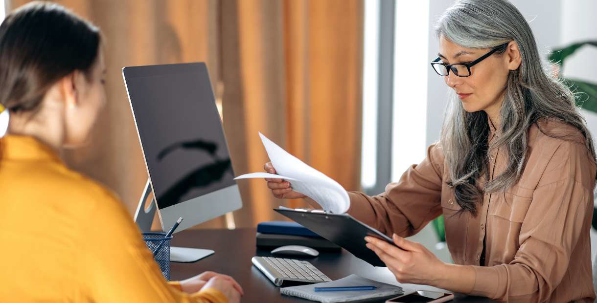 HR manager and employee talking at a desk.