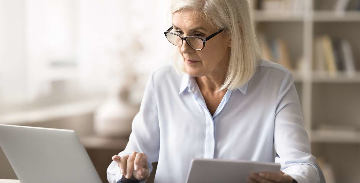 a person with glasses using a laptop.