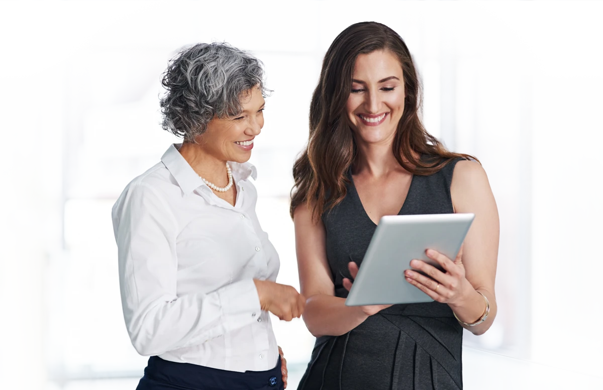 Two professionals reviewing leave benefit information on a tablet.