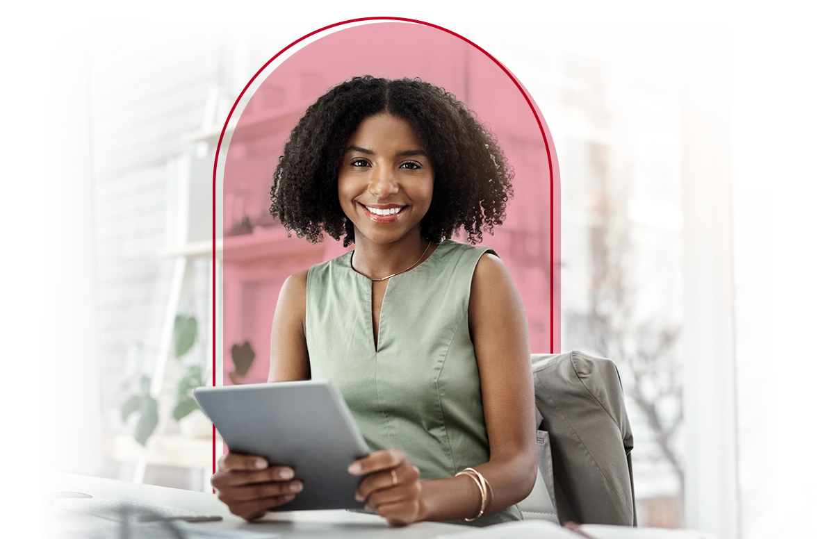 American Fidelity customer smiling at a desk with an tablet in her hand.