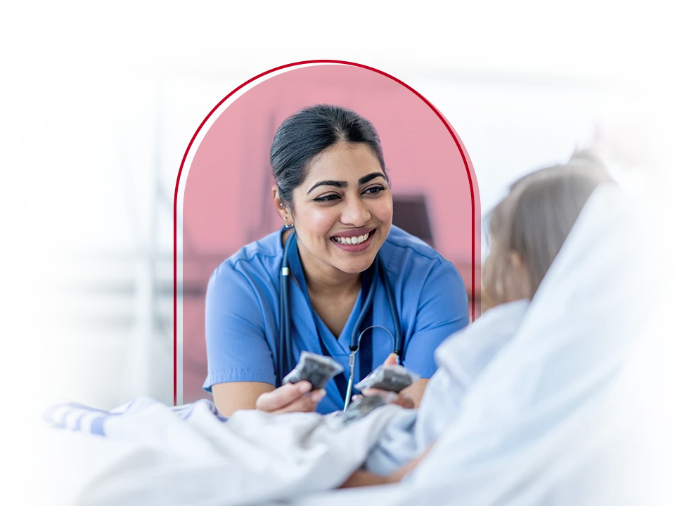Female nurse smiling while talking with a patient.