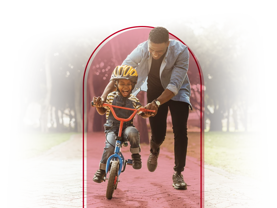 Father helping his child ride a bike.