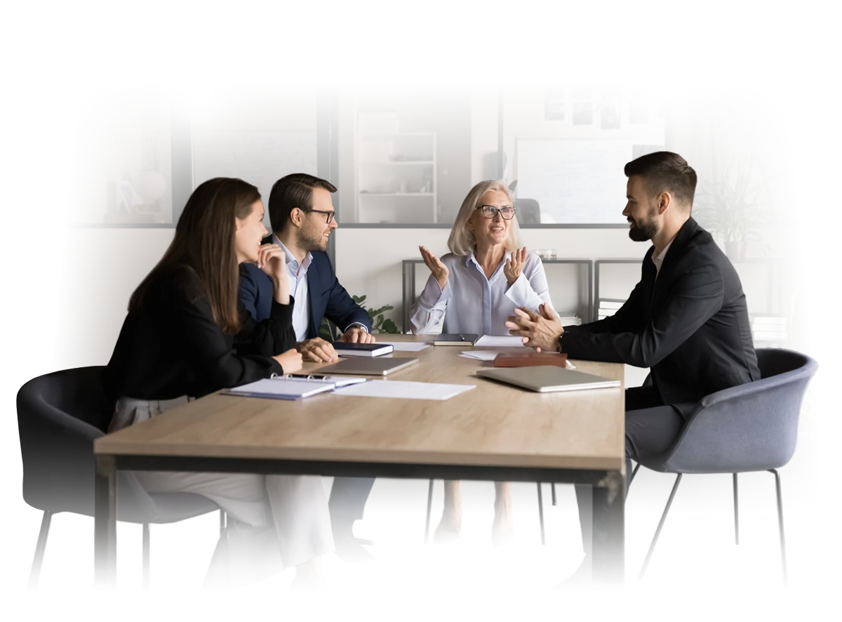 Business people gathered around a table talking.