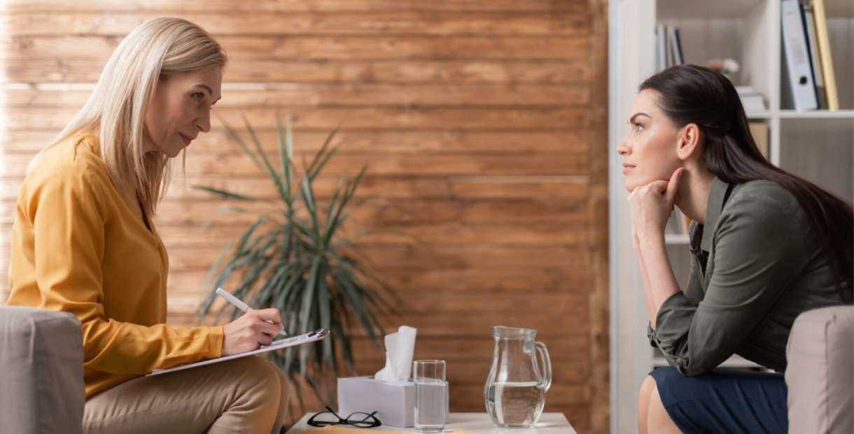 Two women in an office discussing mental health.