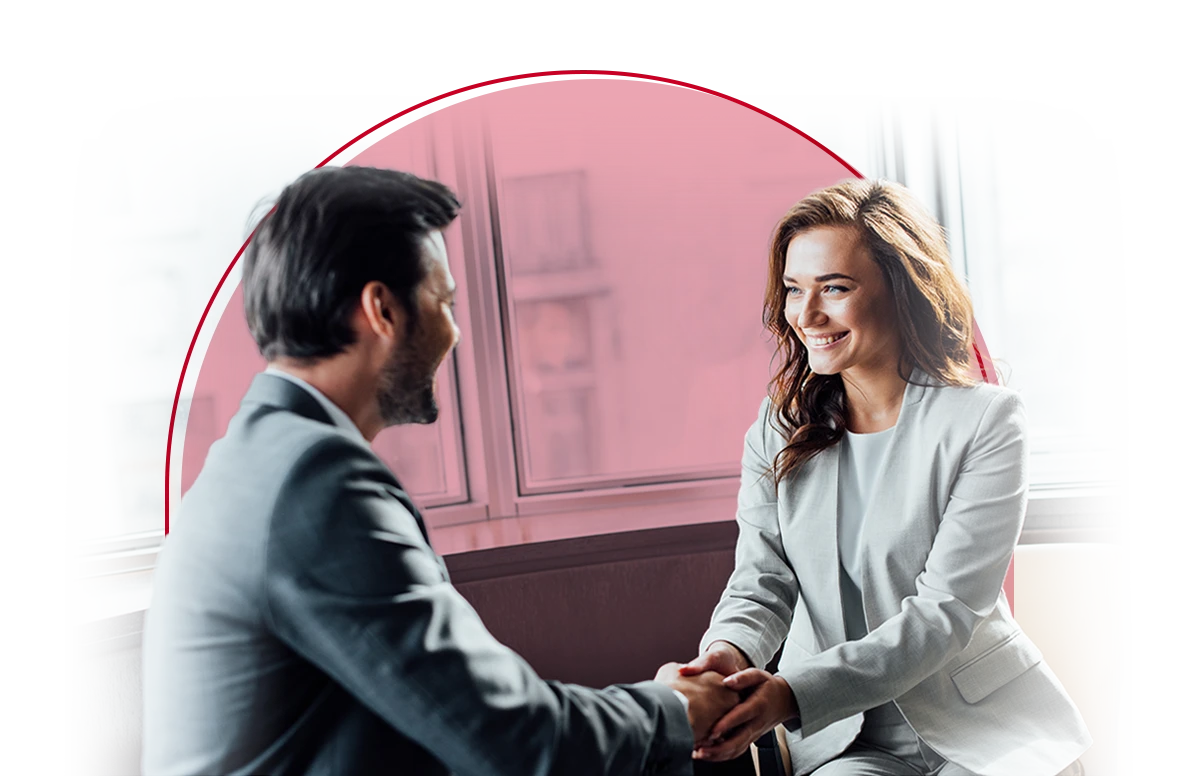 Male and female shake hands during a one-on-one meeting.