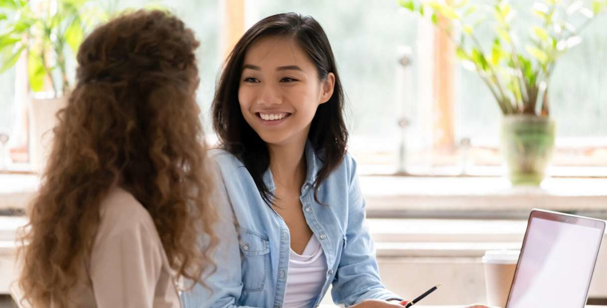 Two women in an office discussing the value of educating employees.
