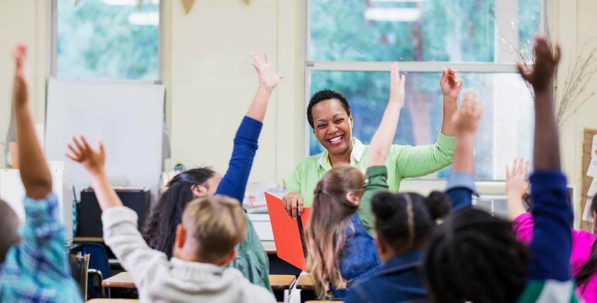 A teacher in a classroom with a group of children.