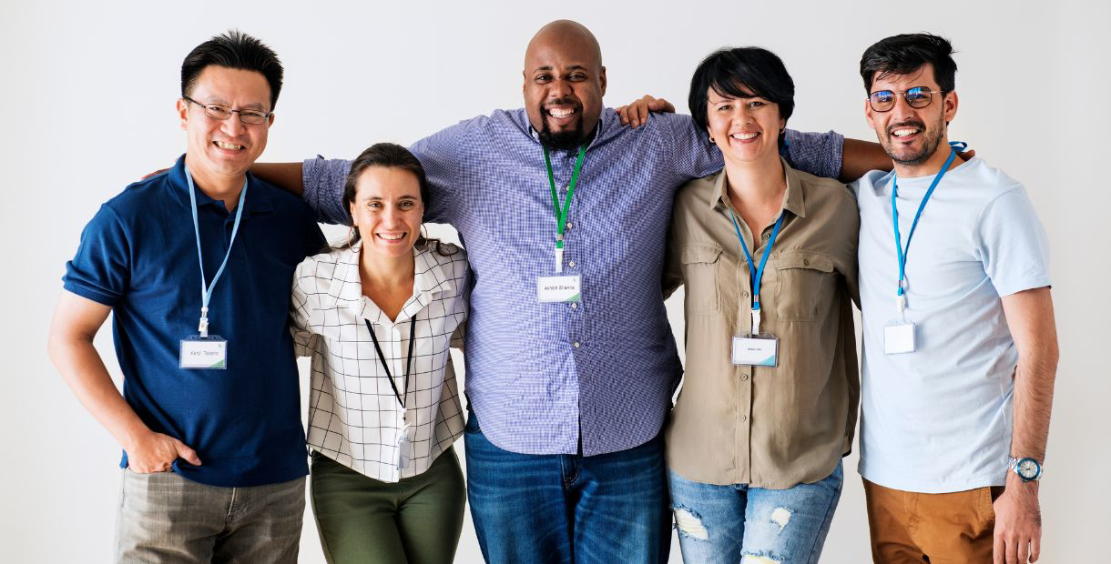 A group of people standing together in front of a white background.