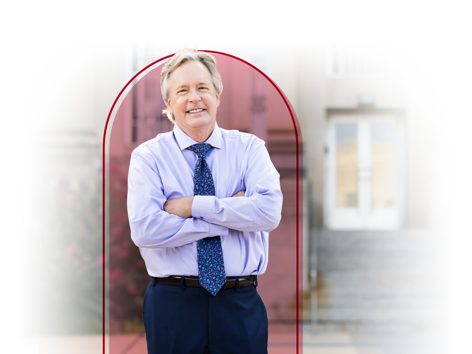 Male in shirt and tie posing in front of a courthouse.
