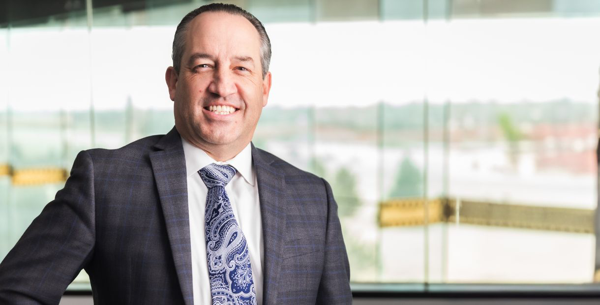 An auto industry CEO smiling for a portrait in his office