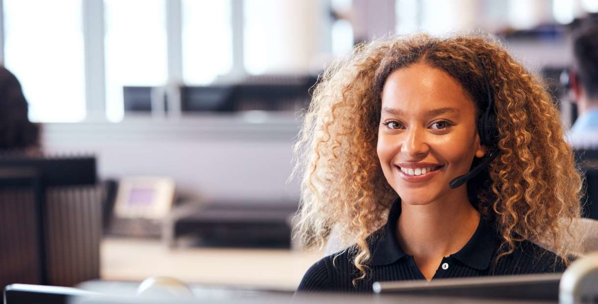 Happy insurance representative in a phone conversation while supporting a customer.