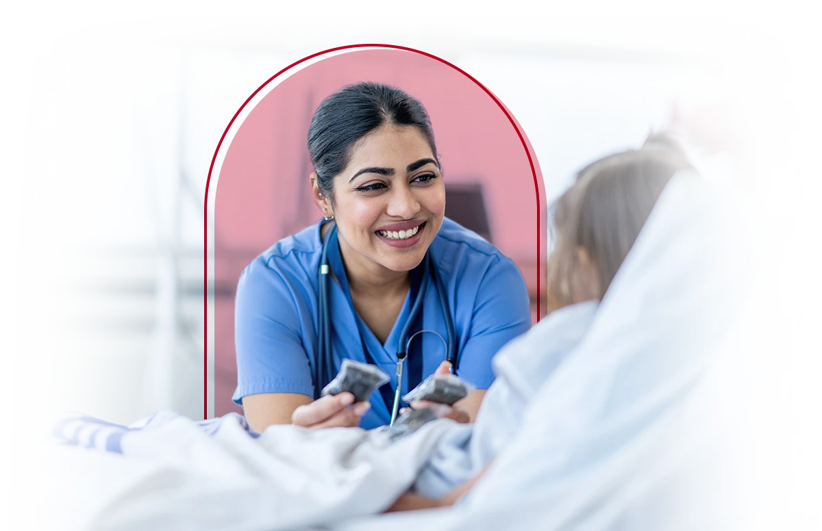 Female nurse smiling while talking with a patient.